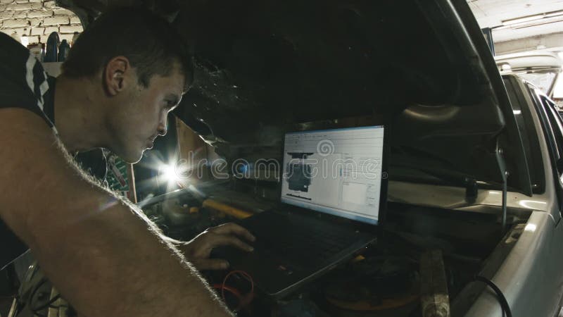 Bilservice, datordiagnostik: mekanikern reparerar skadan genom att använda PC:n i bilservice