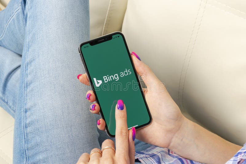 Bing application icon on Apple iPhone X screen close-up in woman hands. Bing ads app icon. Bing ads is online advertising applicat