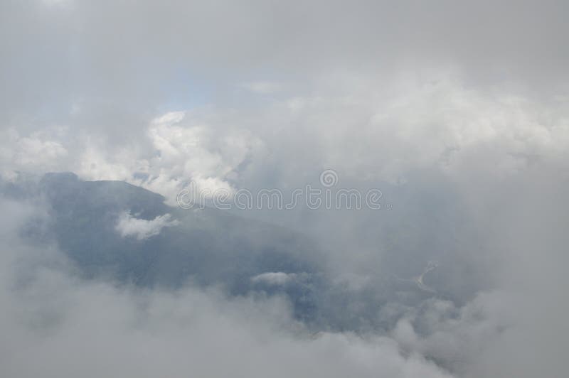 Binnen de wolken Fantastische achtergrond met wolken over bergpieken stock afbeelding Binnen de wolken Fantastische achtergrond met wolken over bergpieken stock afbeelding