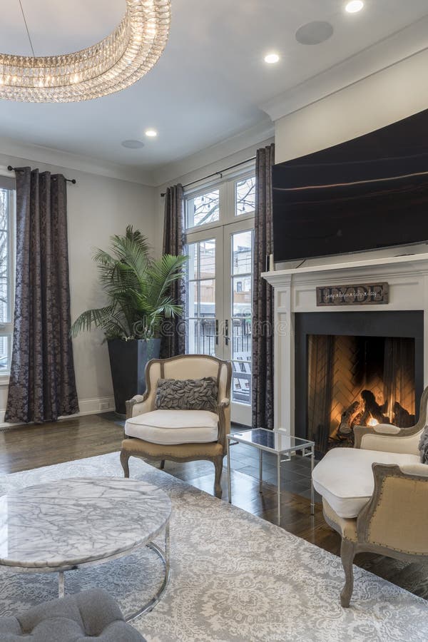 Binnenland van een luxueuze huiswoonkamer met plannen en het groot vlak scherm boven open haard wordt geschoten die royalty-vrije stock foto's Binnenland van een luxueuze huiswoonkamer met plannen en het groot vlak scherm boven open haard wordt geschoten die royalty-vrije stock foto's