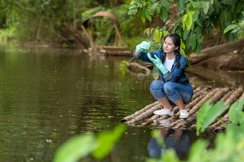 Biologia estudantil asiática colhendo e testando amostras de água fluvial natural Especialistas em ciência mulheres guardam água
