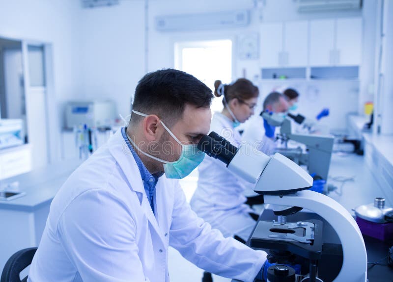 Biologists Looking through Microscope in Laboratory Stock Image Image of occupation