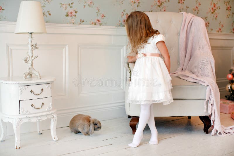 Bionda affascinante molto piacevole della bambina in una condizione bianca del vestito fotografie stock libere da diritti Bionda affascinante molto piacevole della bambina in una condizione bianca del vestito fotografie stock libere da diritti