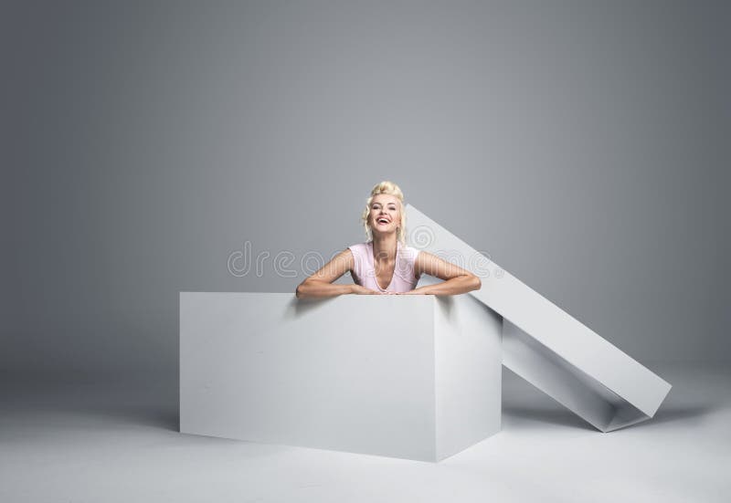 Bionda graziosa che scende il contenitore di regalo immagine stock Bionda graziosa che scende il contenitore di regalo immagine stock