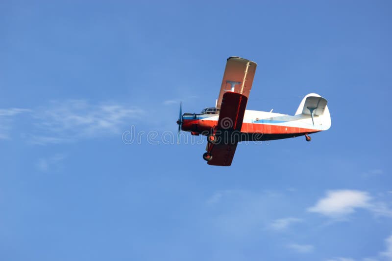 Small retro biplane on blue sky