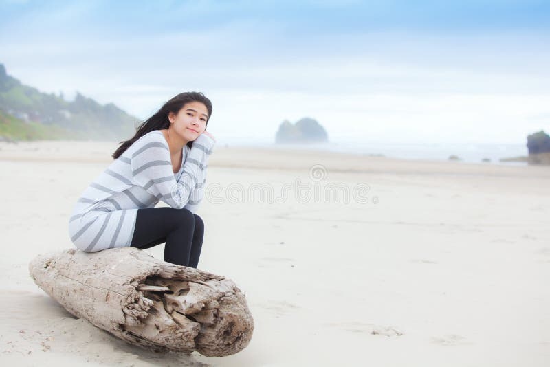 Biracial nastoletni dziewczyny obsiadanie na beli cicho patrzeje ocean fotografia royalty free Biracial nastoletni dziewczyny obsiadanie na beli cicho patrzeje ocean fotografia royalty free