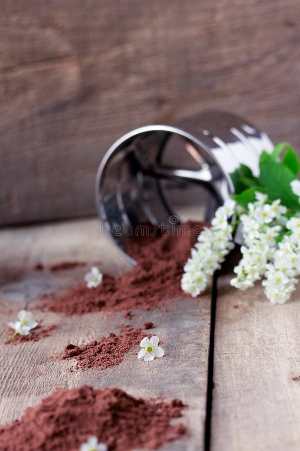 Bird cherry flour with sifter on wooden table