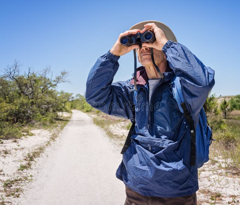 Birdwatching Mann, der auf einem Weg im Nationalpark wandert