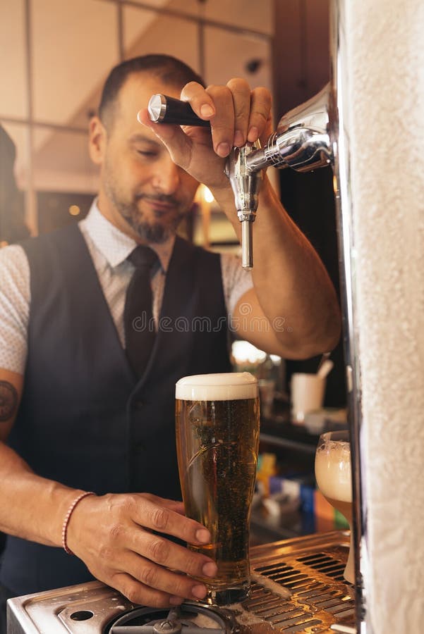 Birra del servizio del barista in un pub fotografie stock libere da diritti Birra del servizio del barista in un pub fotografie stock libere da diritti