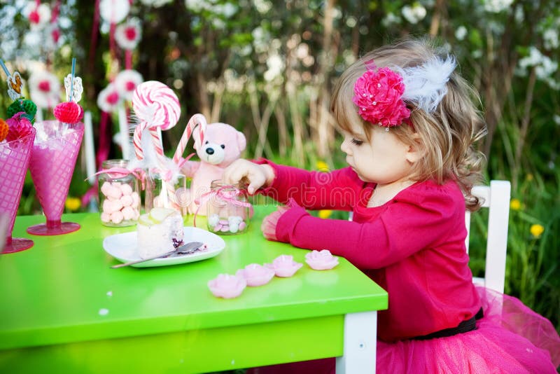 Birthday. Little girl is eating candies on her birthday royalty free stock photo Birthday. Little girl is eating candies on her birthday royalty free stock photo