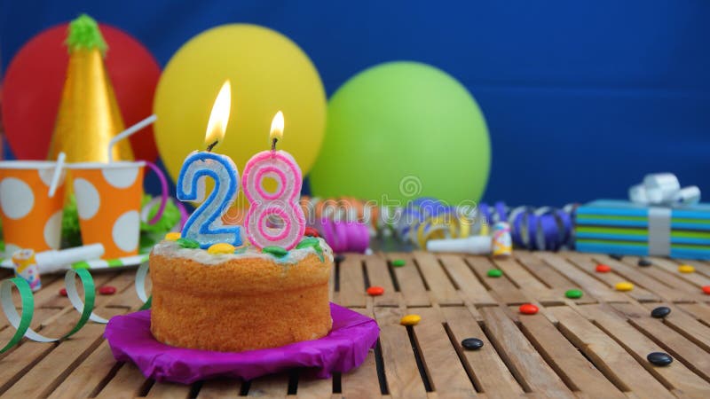 Birthday 28 cake with candles on rustic wooden table with background of colorful balloons, gifts, plastic cups and candies royalty free stock photos Birthday 28 cake with candles on rustic wooden table with background of colorful balloons, gifts, plastic cups and candies royalty free stock photos