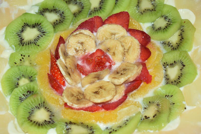 Birthday cake garnished with cream and lots of fresh fruit