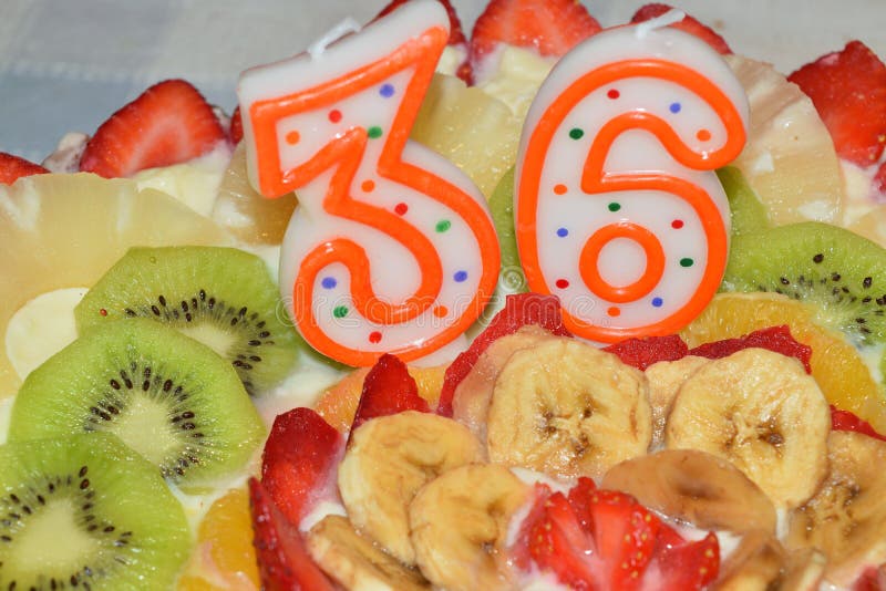 Birthday cake garnished with cream and lots of fresh fruit