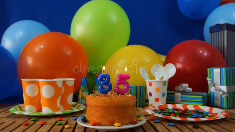 Birthday 35 cake on rustic wooden table with background of colorful balloons, gifts, plastic cups, plastic plate royalty free stock images Birthday 35 cake on rustic wooden table with background of colorful balloons, gifts, plastic cups, plastic plate royalty free stock images