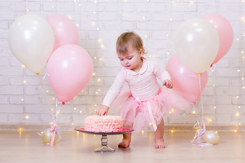 birthday celebration - funny little girl smashing cake over brick wall background with lights and balloons stock image birthday celebration - funny little girl smashing cake over brick wall background with lights and balloons stock image