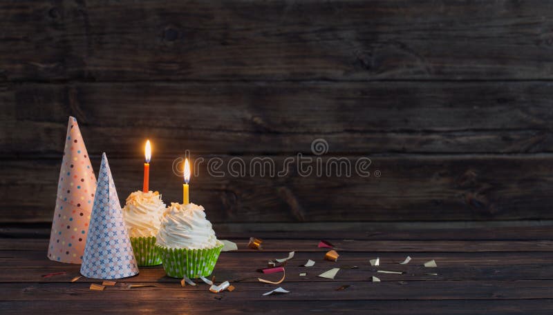Birthday cupcakes with candles on old dark wooden background stock image Birthday cupcakes with candles on old dark wooden background stock image