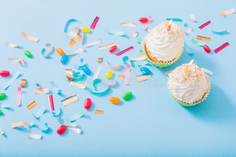 Birthday hat with confetti and cupcake on blue paper background royalty free stock image Birthday hat with confetti and cupcake on blue paper background royalty free stock image