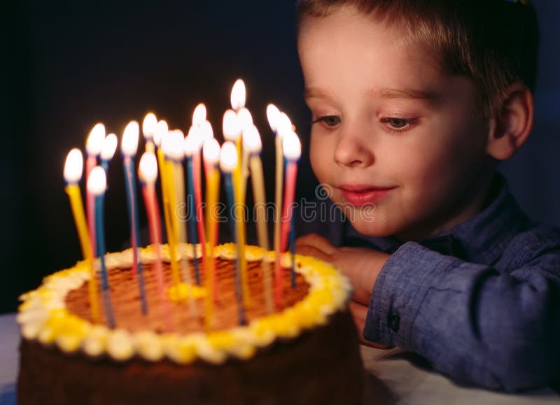 Birthday A Little Boy Blows Out Candles On The Stoke Stock Photo