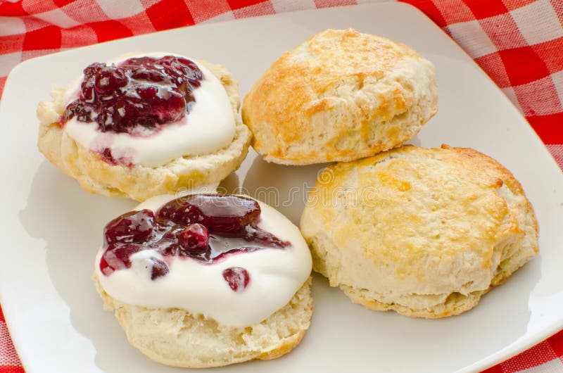 Biscuits (scones) with whipped cream and blackcurrant jam. Biscuits (scones) with whipped cream and blackcurrant jam