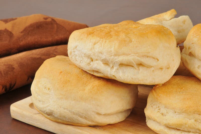 Fresh baked buttermilk biscuits on a cutting board with a towel. Fresh baked buttermilk biscuits on a cutting board with a towel