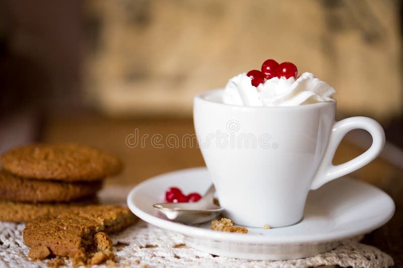 Crumbling oat cookies biscuits with hot coffee and whipped cream with cranberries on top. Shallow DOF. Crumbling oat cookies biscuits with hot coffee and whipped cream with cranberries on top. Shallow DOF