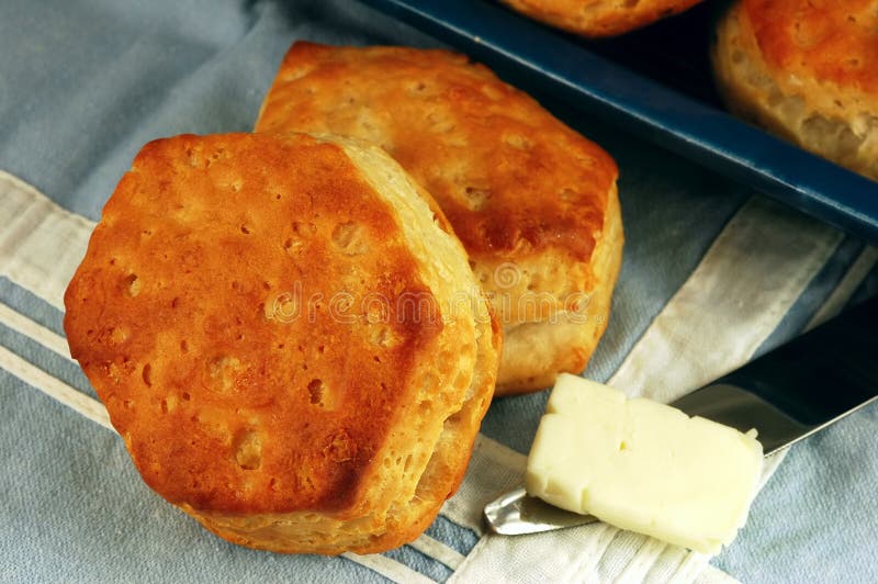 Homemade buttermilk biscuits with butter on a vintage blue table linen. Homemade buttermilk biscuits with butter on a vintage blue table linen