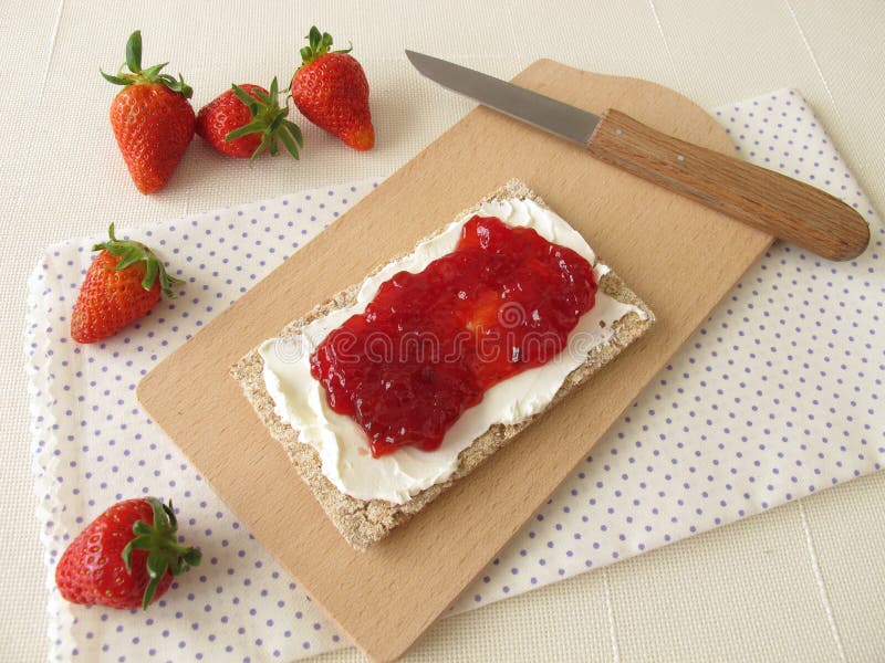 Biscote curruscante con el queso cremoso y la mermelada de fresa fotografía de archivo libre de regalías Biscote curruscante con el queso cremoso y la mermelada de fresa fotografía de archivo libre de regalías