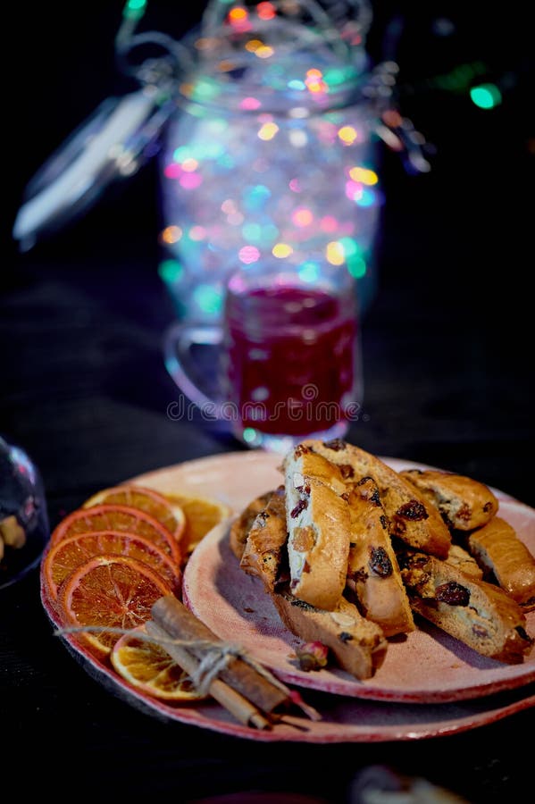 Biscotti de la galleta en un fondo oscuro Un vidrio de vino rojo o de vino reflexionado sobre Guirnalda de la Navidad foto de archivo Biscotti de la galleta en un fondo oscuro Un vidrio de vino rojo o de vino reflexionado sobre Guirnalda de la Navidad foto de archivo