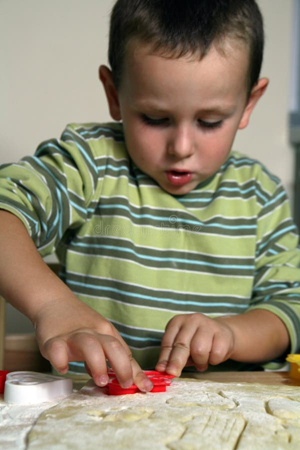 4 years old boy cutting out cookies. 4 years old boy cutting out cookies