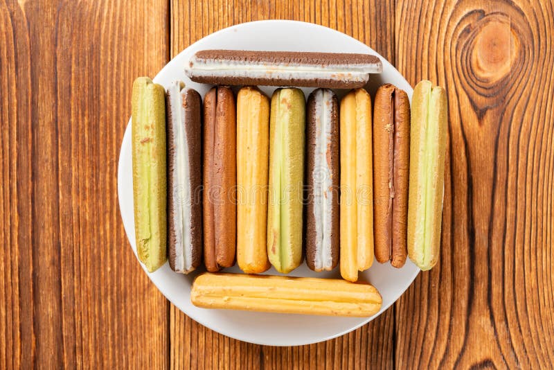 Biscotti multicolori del panino su una tavola di legno immagine stock libera da diritti Biscotti multicolori del panino su una tavola di legno immagine stock libera da diritti