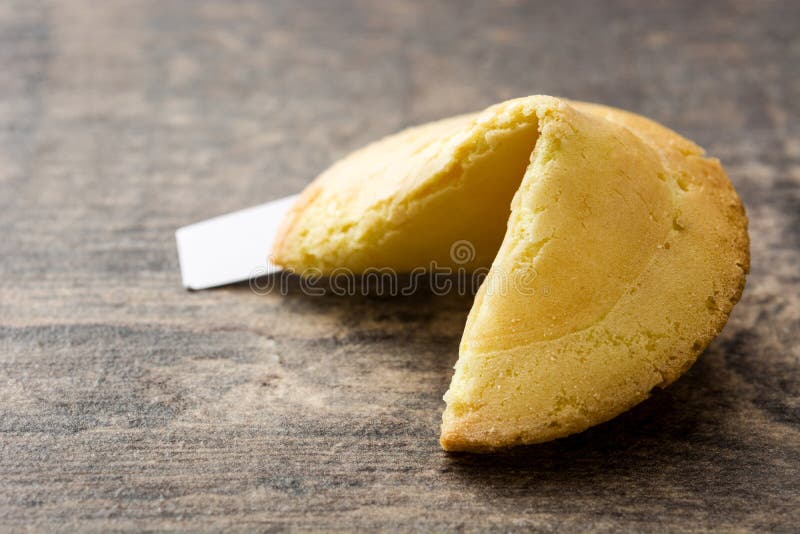 Biscotto di fortuna sulla tavola di legno immagini stock libere da diritti Biscotto di fortuna sulla tavola di legno immagini stock libere da diritti