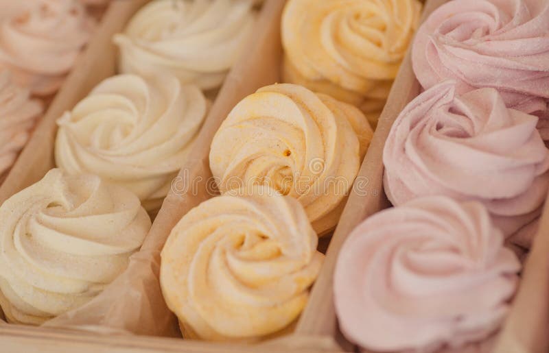 Biscuit meringue with an air cream of different colors in box for sale, inside a sweet shop