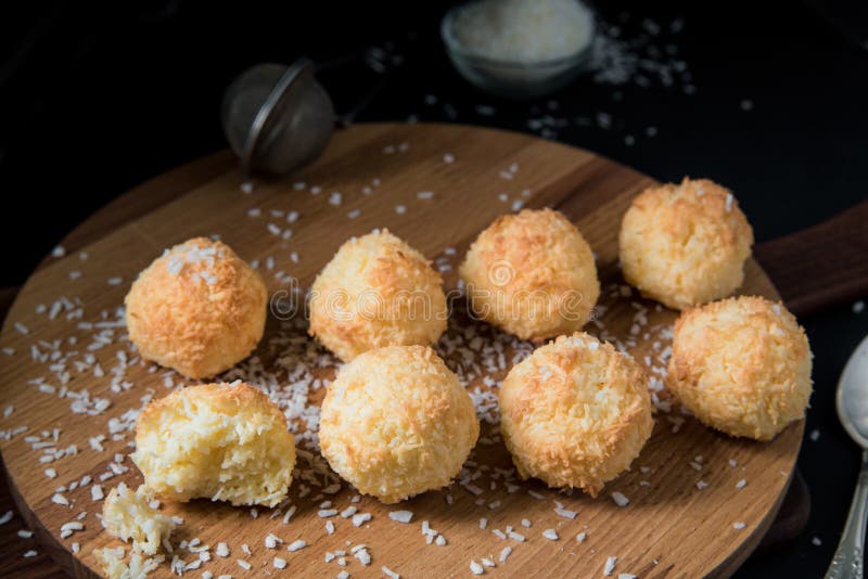 Biscuits croquants Congolais de noix de coco sur un conseil en bois sur un fond foncé image libre de droits Biscuits croquants Congolais de noix de coco sur un conseil en bois sur un fond foncé image libre de droits