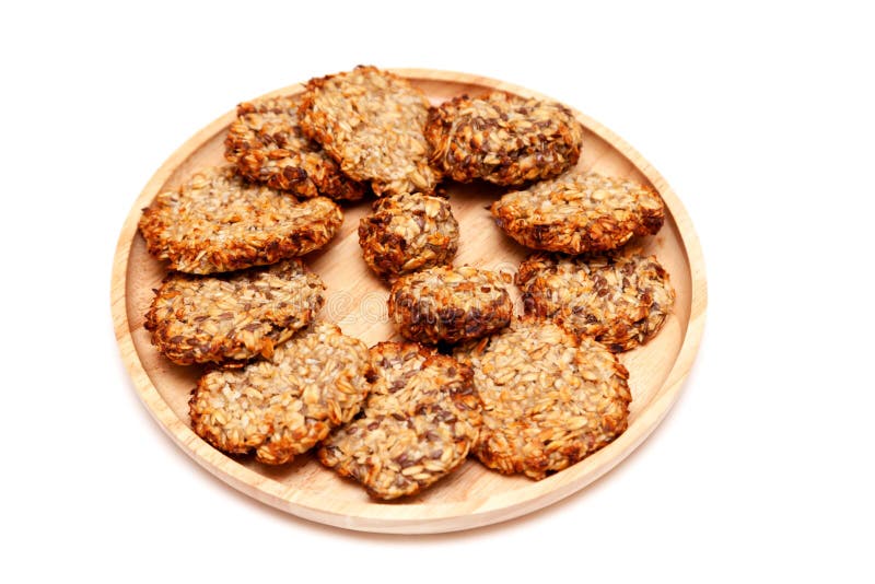Biscuits maigres diététiques de farine d'avoine naturelle faite maison de plan rapproché avec des graines d'un plat en bois ro photo stock Biscuits maigres diététiques de farine d'avoine naturelle faite maison de plan rapproché avec des graines d'un plat en bois ro photo stock