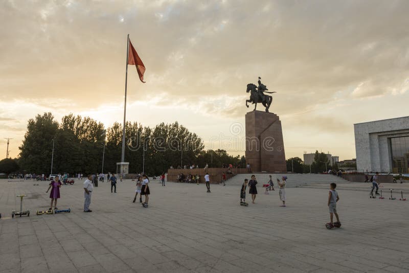 Bishkek, Kyrgyzstan 9 Augustus 2018: De ingezetenen van Bishkek komen bij zonsondergang in het vierkant voor het Historische Muse stock afbeelding Bishkek, Kyrgyzstan 9 Augustus 2018: De ingezetenen van Bishkek komen bij zonsondergang in het vierkant voor het Historische Muse stock afbeelding