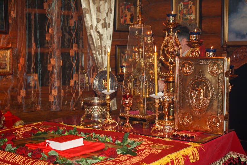 Biskopsstol med det heliga evangeliet, de brännande stearinljusen, relikerna av helgonen och menororna med brinnande lampor i alt royaltyfri bild Biskopsstol med det heliga evangeliet, de brännande stearinljusen, relikerna av helgonen och menororna med brinnande lampor i alt royaltyfri bild