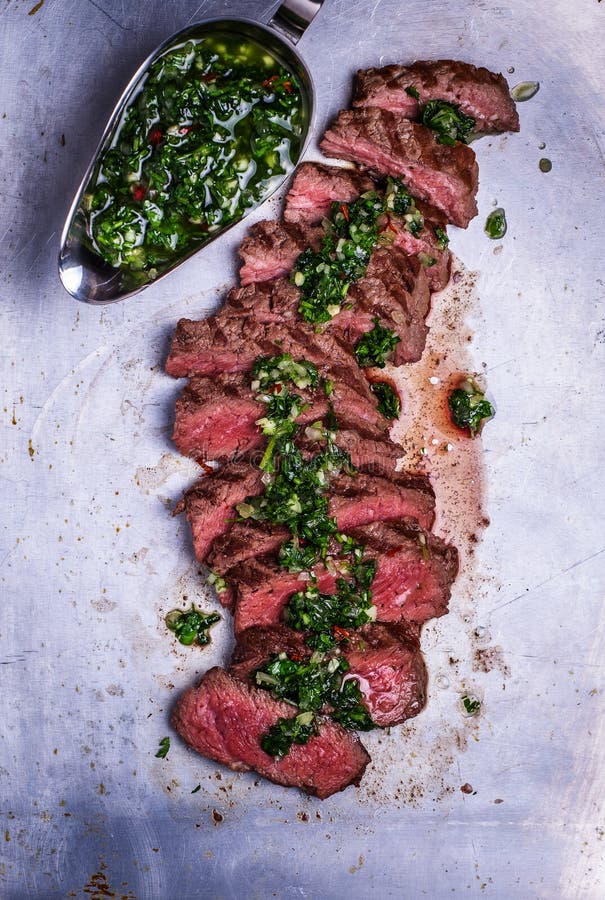 Bistecca affettata del barbecue del manzo con la salsa di chimichurri fotografia stock Bistecca affettata del barbecue del manzo con la salsa di chimichurri fotografia stock
