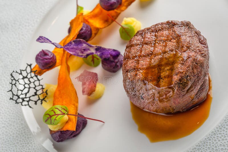 Bistecca di manzo deliziosa con salsa e la verdura, servite sul piatto bianco, gastronomie moderna, ristorante di michelin fotografie stock libere da diritti