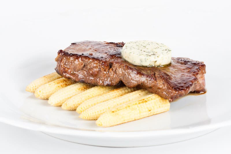 Bistecca di manzo deliziosa sul piatto bianco con cereale immagini stock