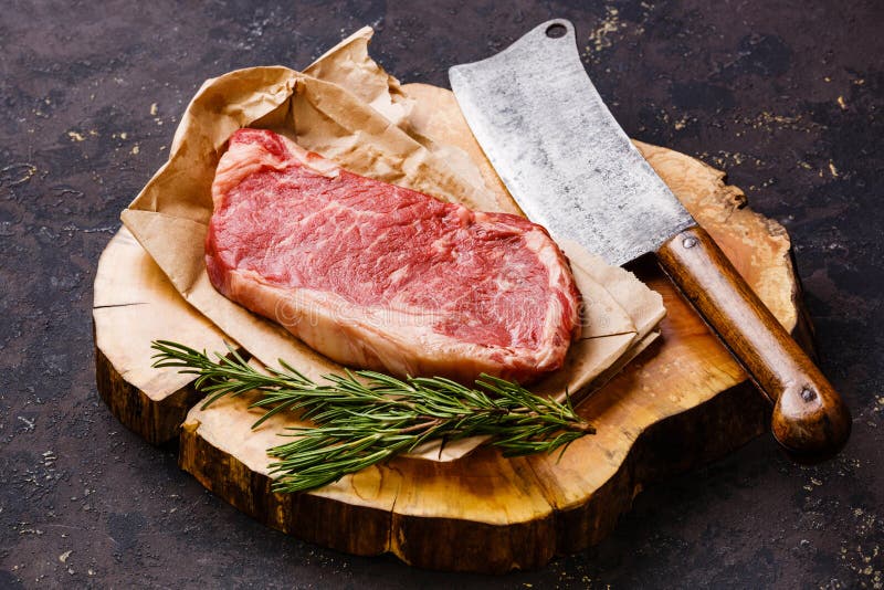 Bistecca di Striploin della carne cruda e mannaia di carne fotografia stock Bistecca di Striploin della carne cruda e mannaia di carne fotografia stock