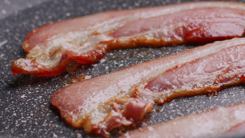 Bitar av krispy flavorful bacon som frigjorts i form av panna