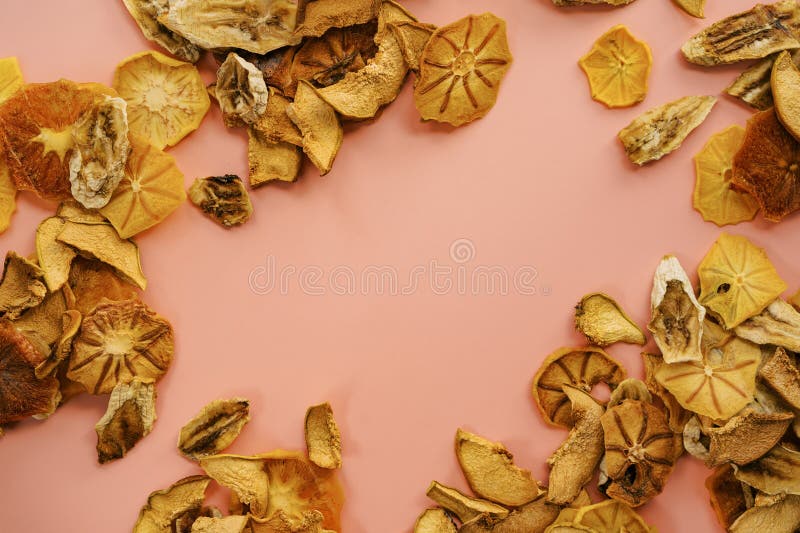 Bitar av torkad frukt, ram, rosa bakgrund arkivfoto