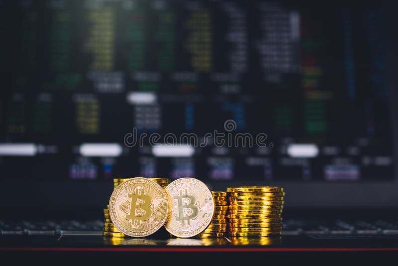 Bitcoin coins pile and two bit coins sitting in front with stock index graph chart digital background. Concept of Bitcoin stock photography