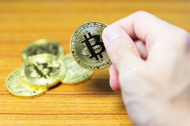 Bitcoin a disposición con un fondo borroso del bitcoin foto de archivo Bitcoin a disposición con un fondo borroso del bitcoin foto de archivo