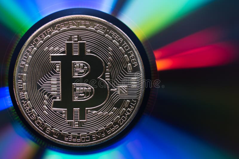 Bitcoin dourado em uma superfície multicolorido iridescente reflexiva imagem de stock Bitcoin dourado em uma superfície multicolorido iridescente reflexiva imagem de stock