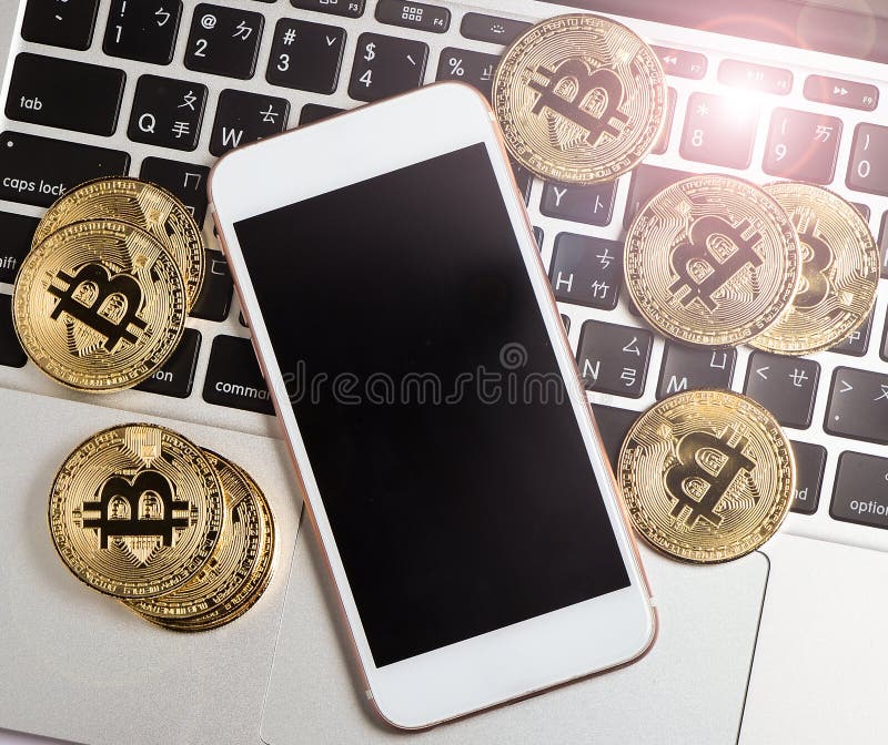 Bitcoin e il iphone sul computer portatile con un alone d'ardore, Bitcoin è una valuta cripto immagine stock libera da diritti Bitcoin e il iphone sul computer portatile con un alone d'ardore, Bitcoin è una valuta cripto immagine stock libera da diritti