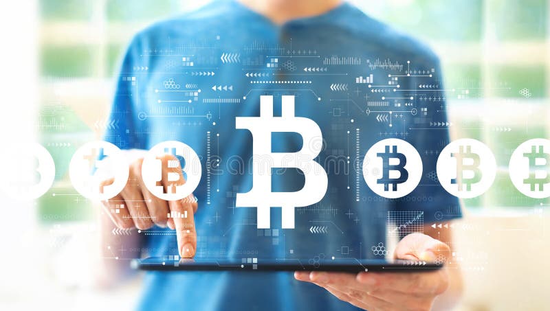 Bitcoin theme with man using a tablet stock photography