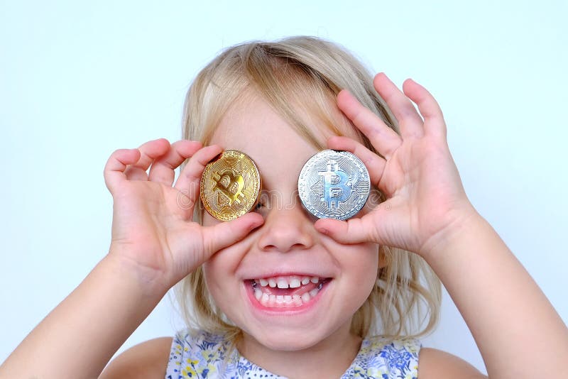 Bitcoin glasses, stacks of euro currency coins, small child, blonde girl 3 years old holds bitcoin crypto currency coins in hands, financial literacy of children, Electronic decentralized money. Bitcoin glasses, stacks of euro currency coins, small child, blonde girl 3 years old holds bitcoin crypto currency coins in hands, financial literacy of children, Electronic decentralized money