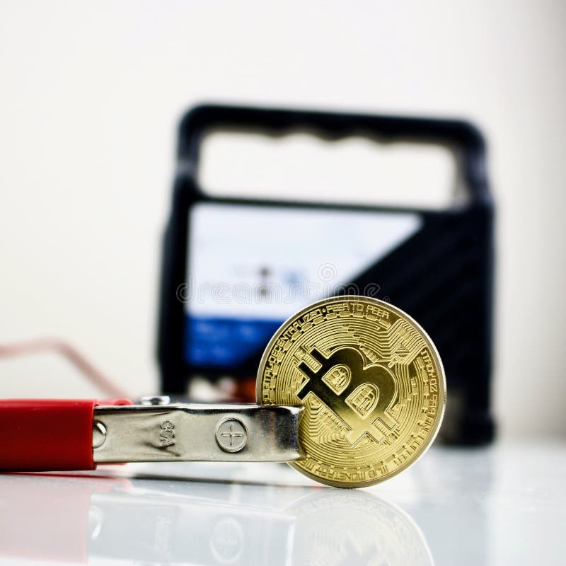 Bitcoin złocista moneta i samochodowa bateryjna ładowarka zdjęcie royalty free Bitcoin złocista moneta i samochodowa bateryjna ładowarka zdjęcie royalty free