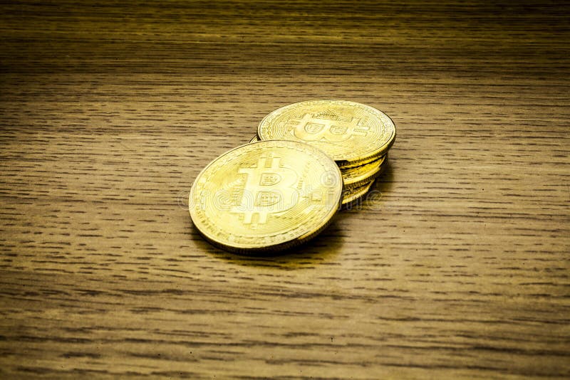 Bitcoins dourados na mesa de madeira, fundo do cryptocurrency imagens de stock Bitcoins dourados na mesa de madeira, fundo do cryptocurrency imagens de stock